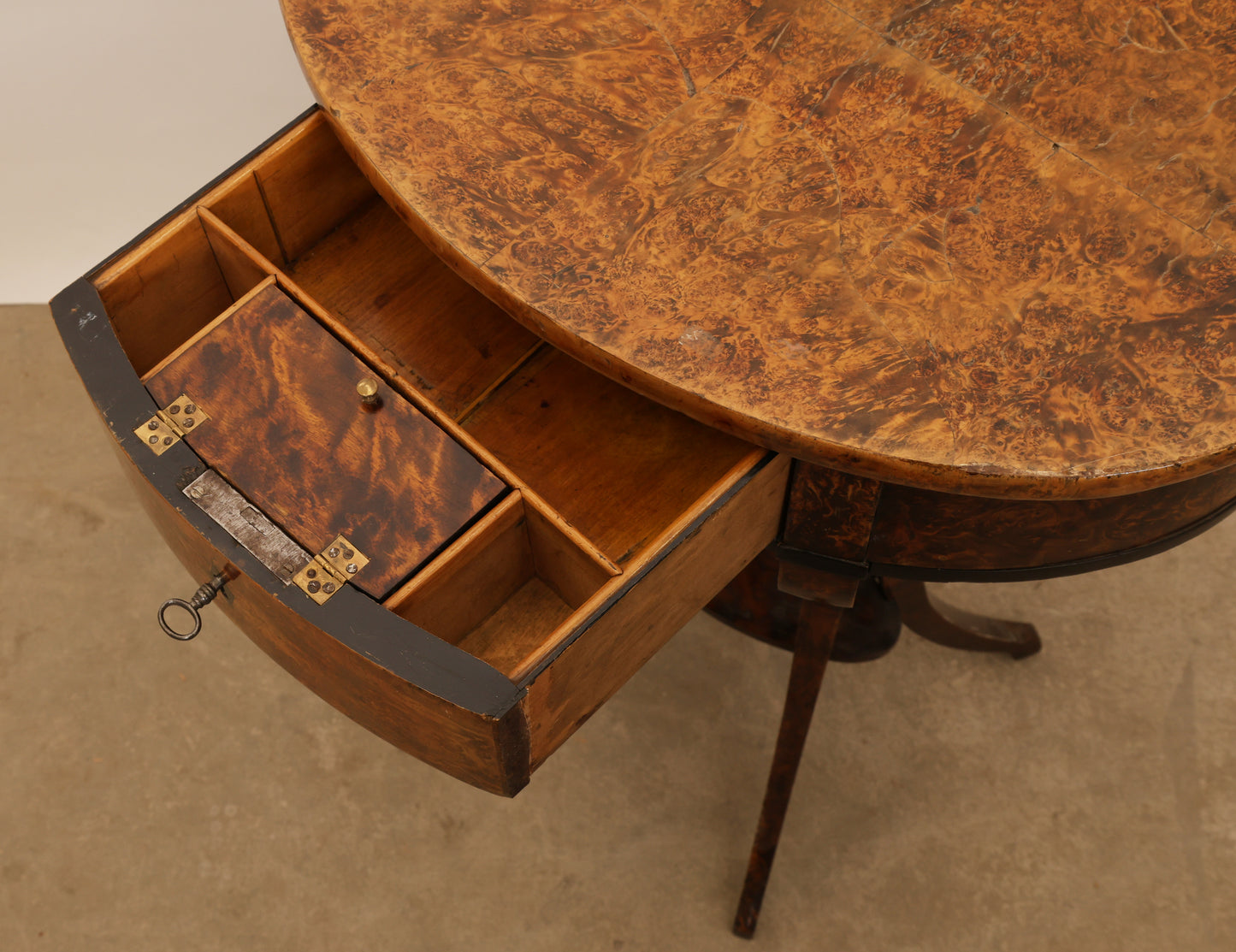 Opened drawers of an antique table from the early 19th century in veneered root.