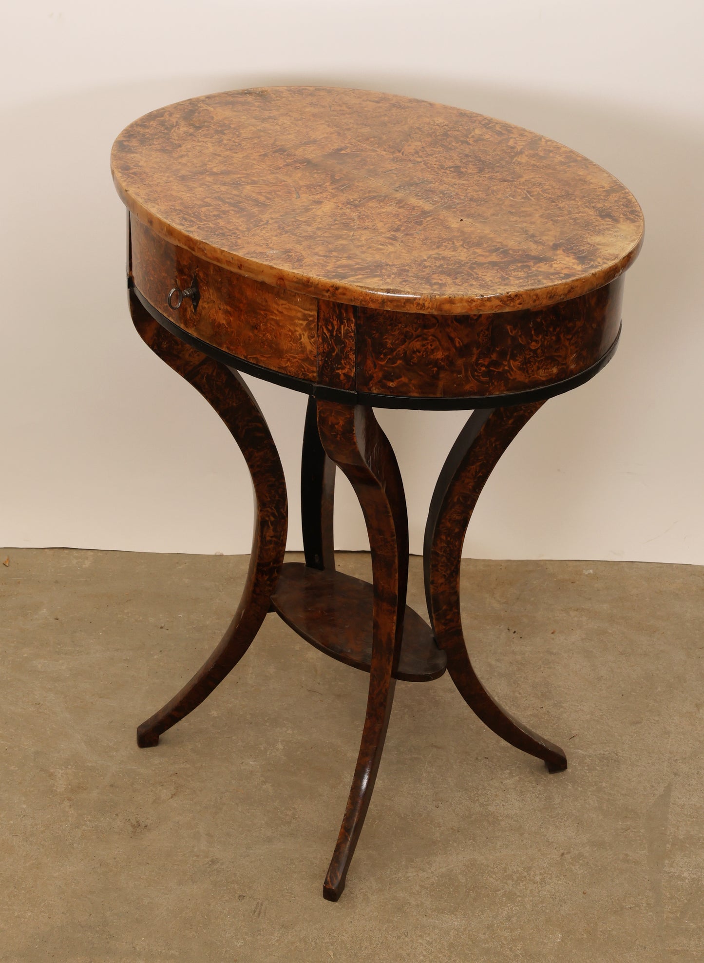 An early 19th century antique table veneered in root for sale, angle from the side.