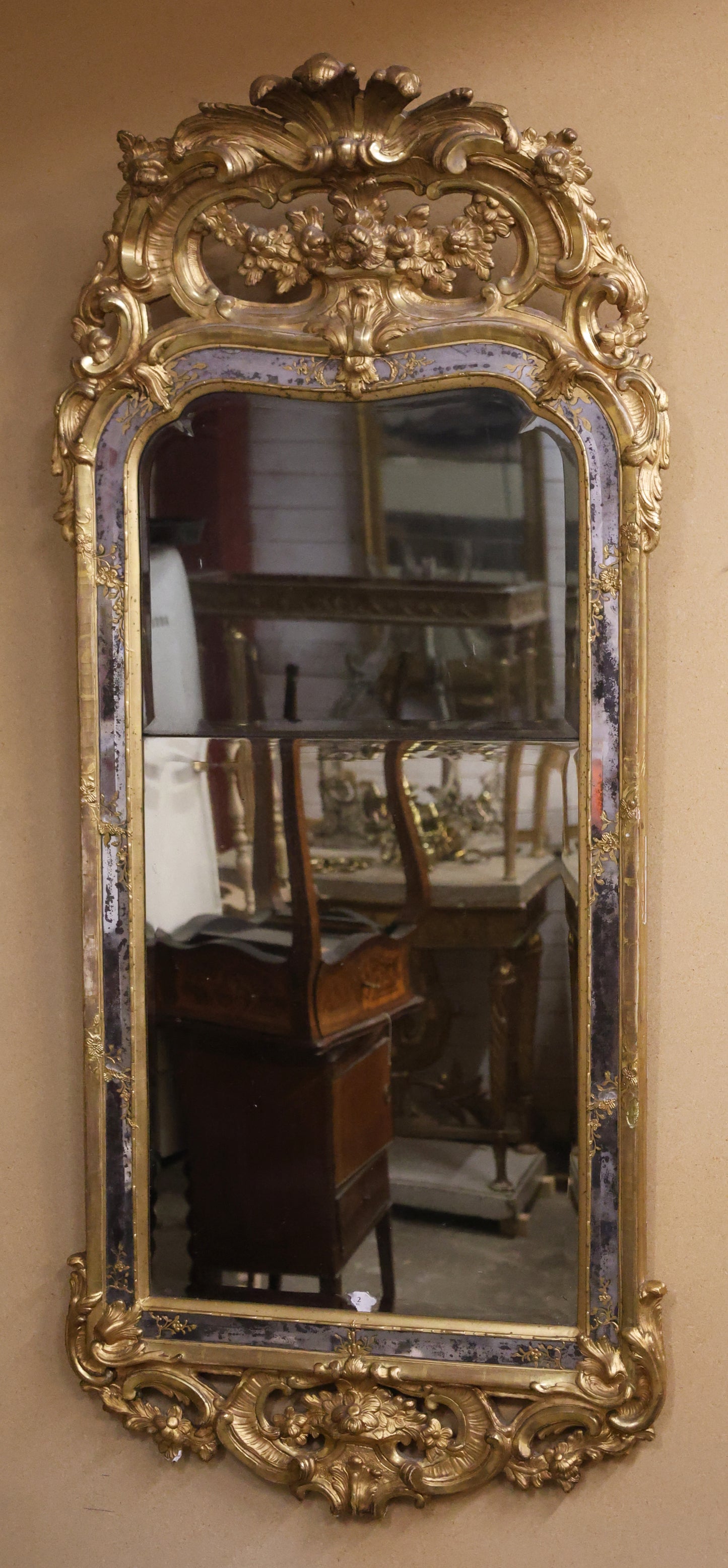 An antique Rococo mirror that is gilded and from the 18th century.