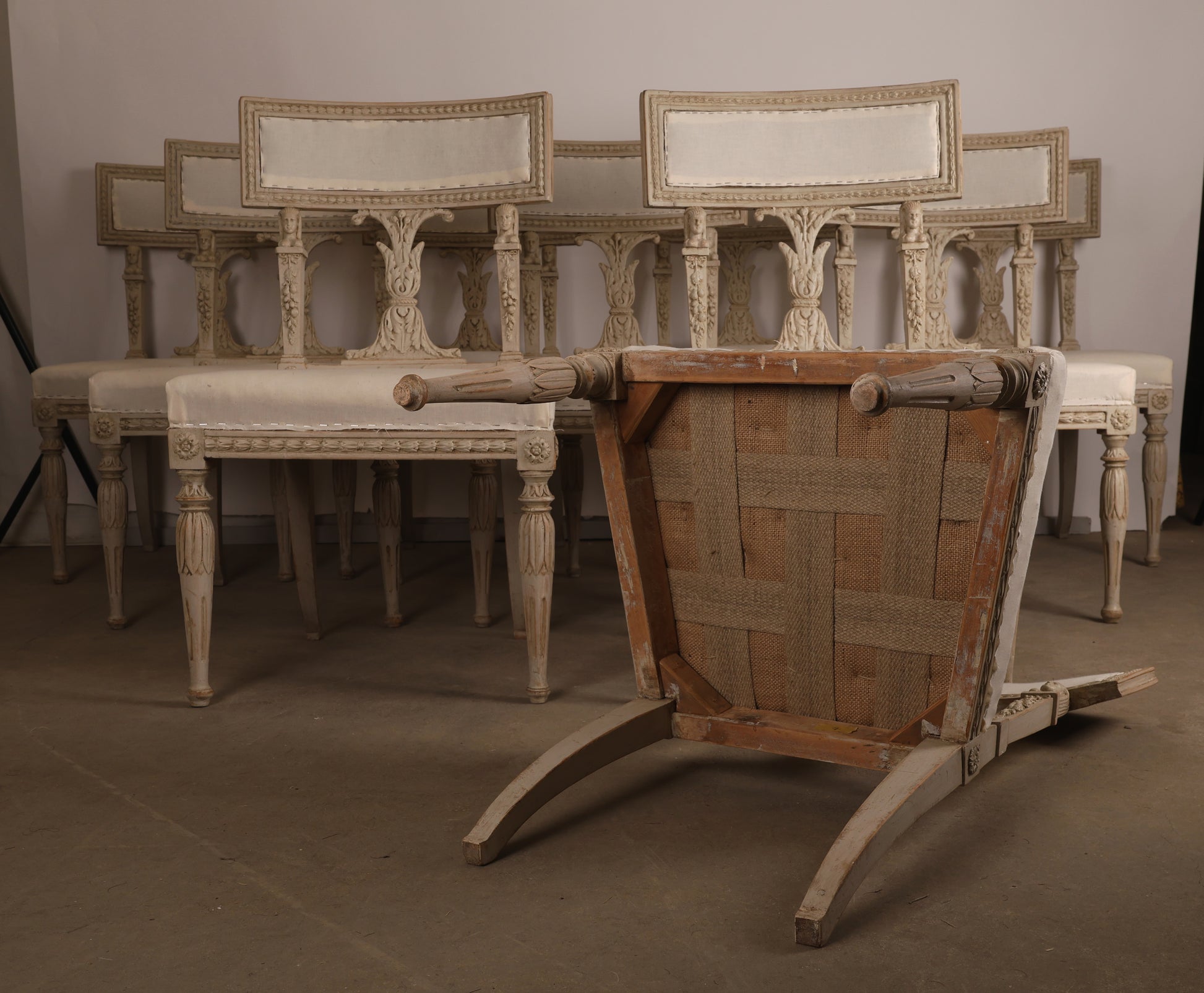 Set of 10 Late Gustavian Chairs attributed to Ephraim Ståhl with one of the chairs laying on the floor showcasing the chair underneath