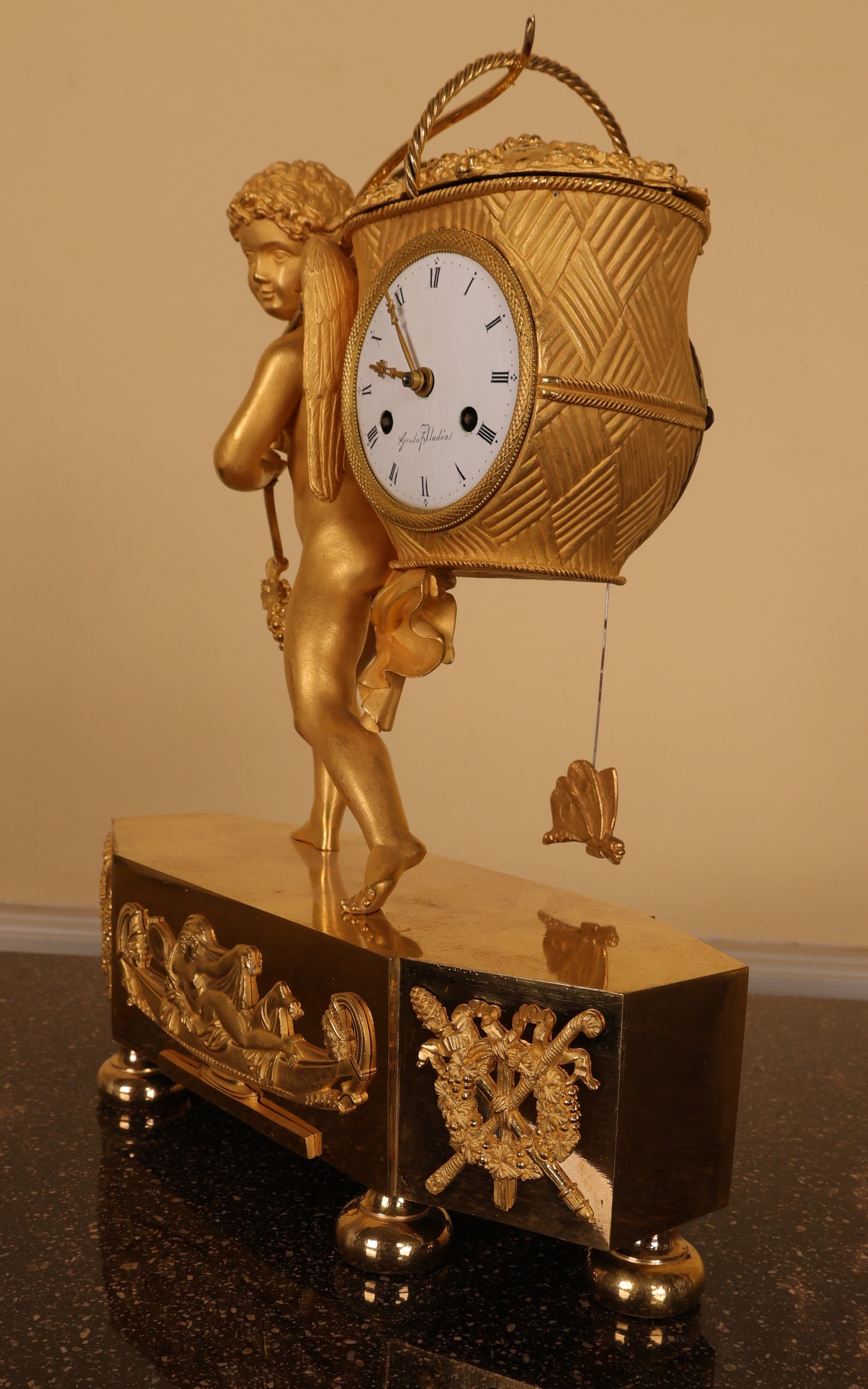 An antique mantel clock in burnished-gilded bronze.