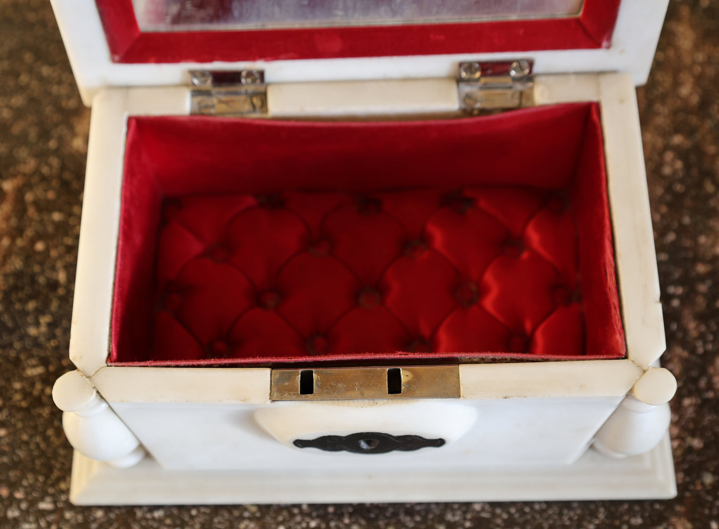 Opened lidded box in marble with red velvet.