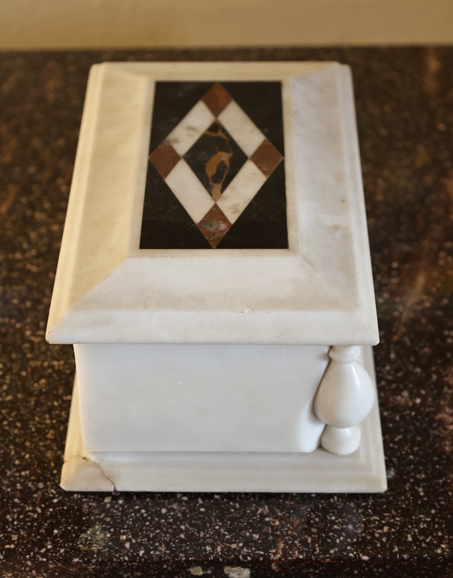 Side view of an antique lidded box in marble