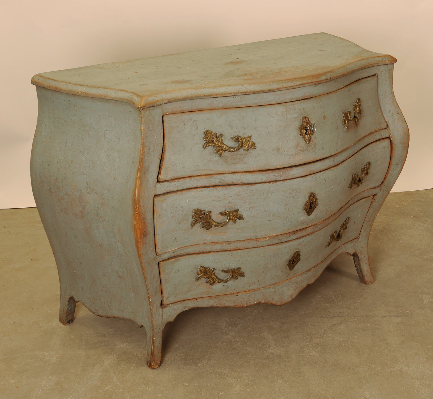 A blue Rococo chest of drawers.
