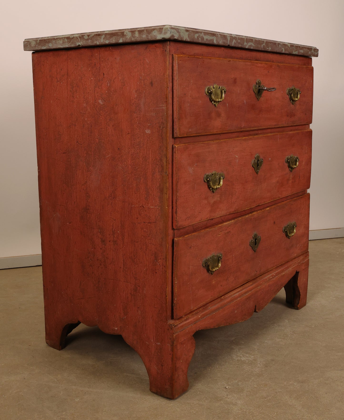 Side view of a red Baroque Commode