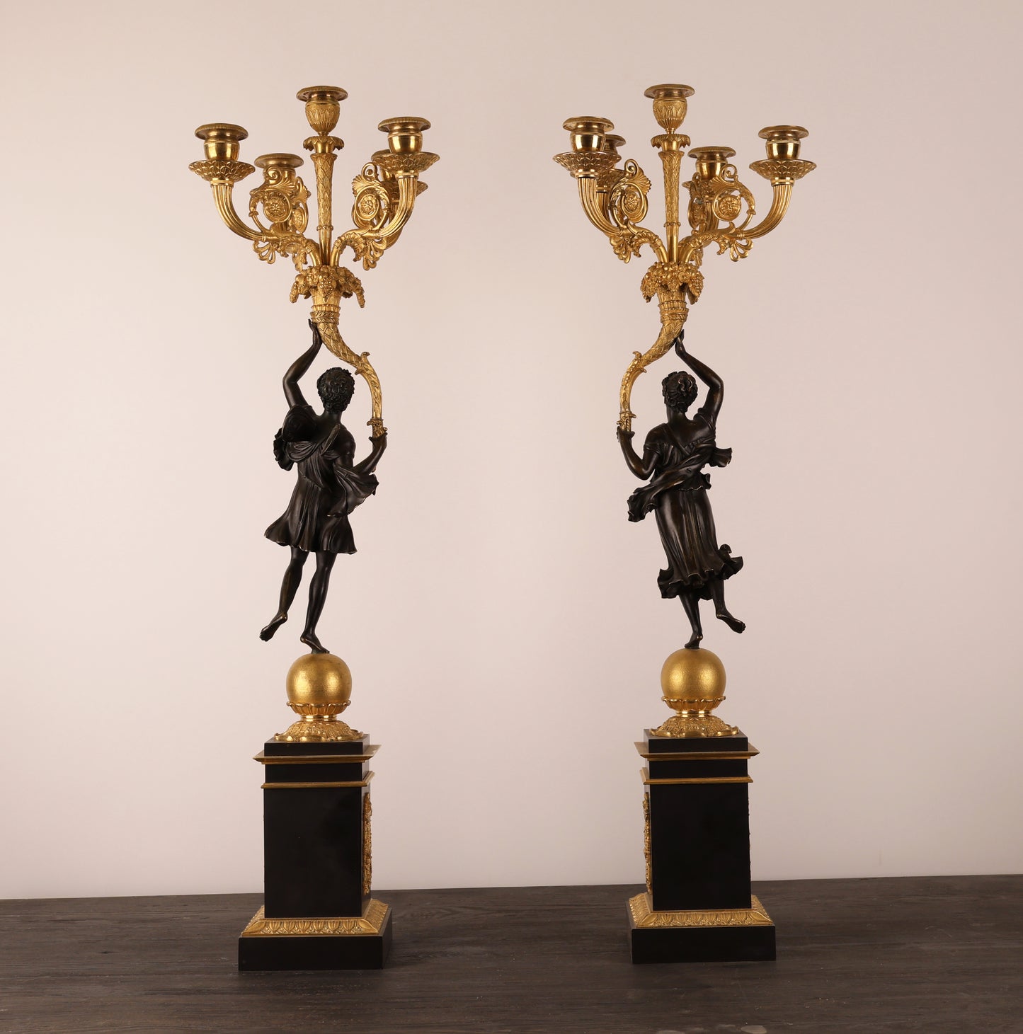 Backview of a pair of 19th century Empire candelabras by Pierre Chibout in patinated and burnished-gilded bronze.