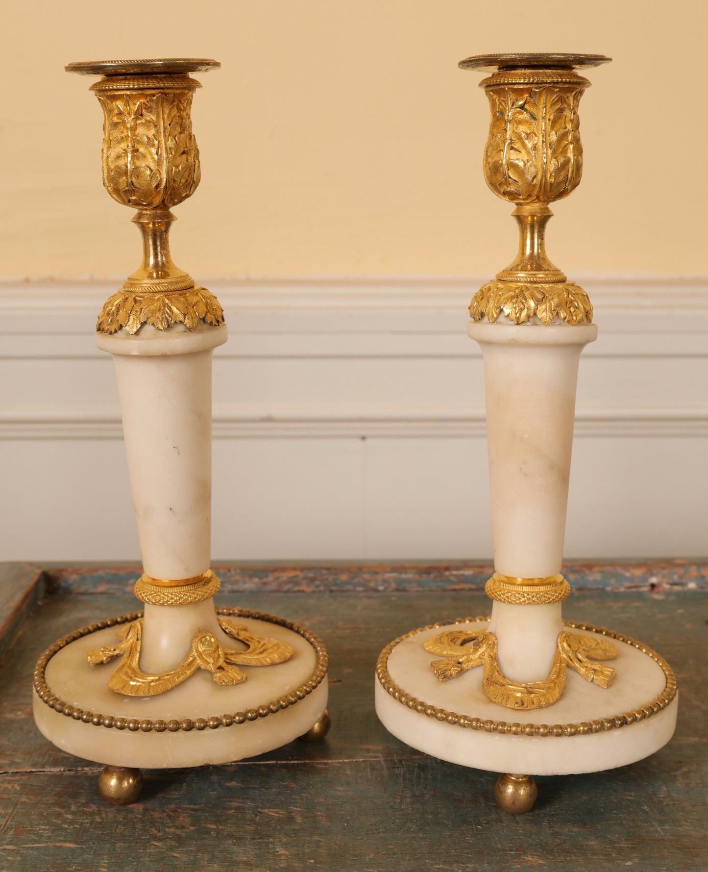 A pair of Louis XVI white carrara marble and burnished-gilded bronze candlesticks for sale.