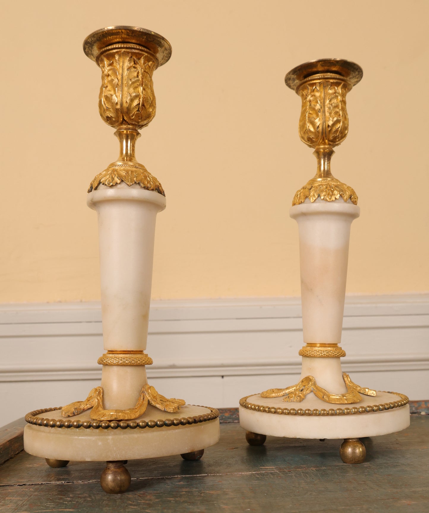A pair of louis xvi candlesticks in white carrara marble and fire-gilded bronze.