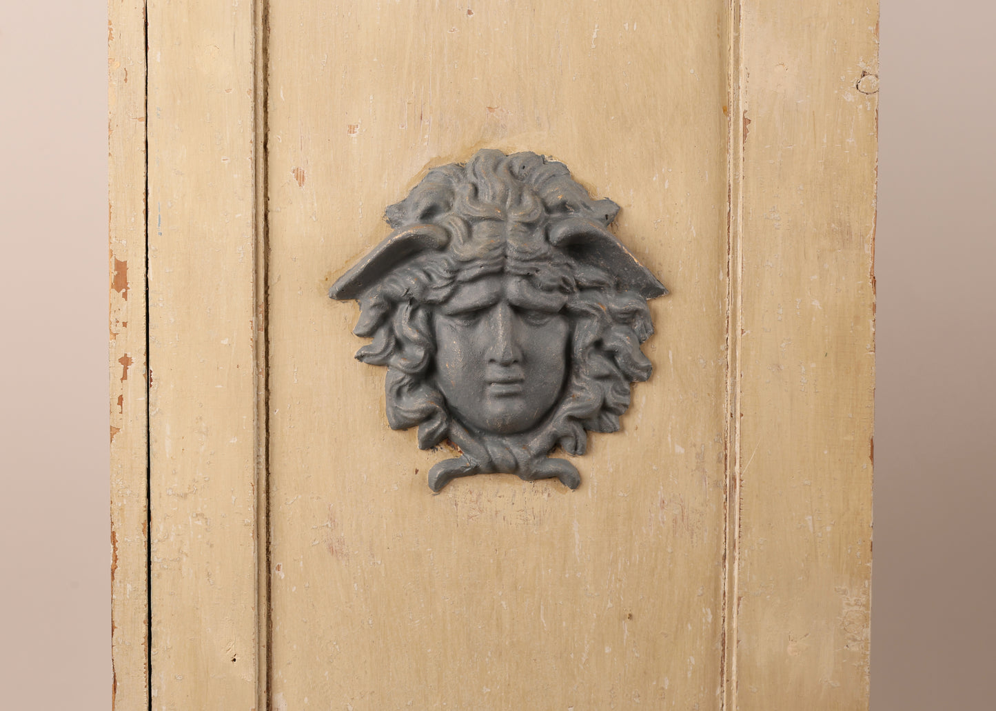 Close up of medusa head decoration on a 19th Century Gustavian Column Cabinet.