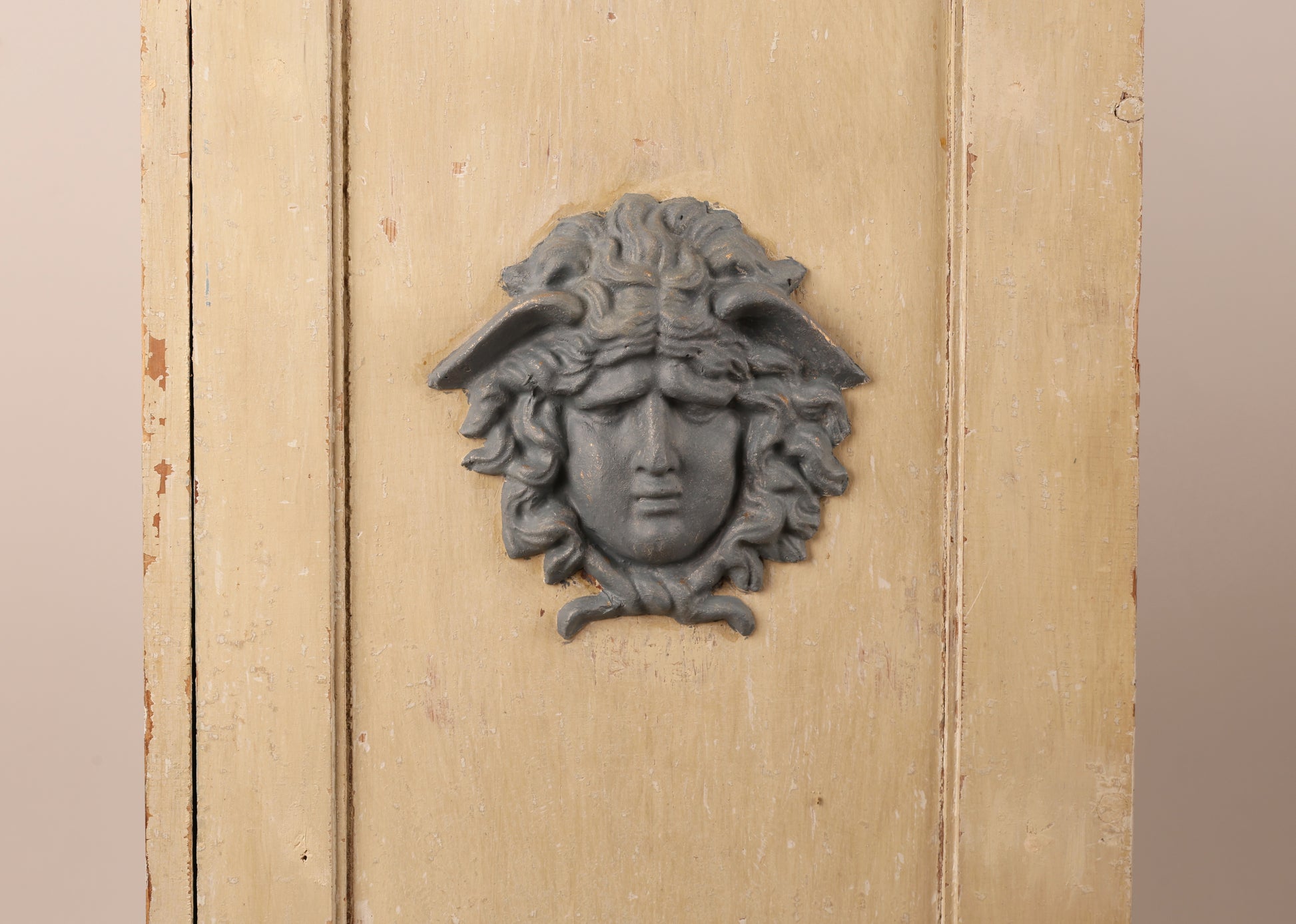 Close up of medusa head decoration on a 19th Century Gustavian Column Cabinet.