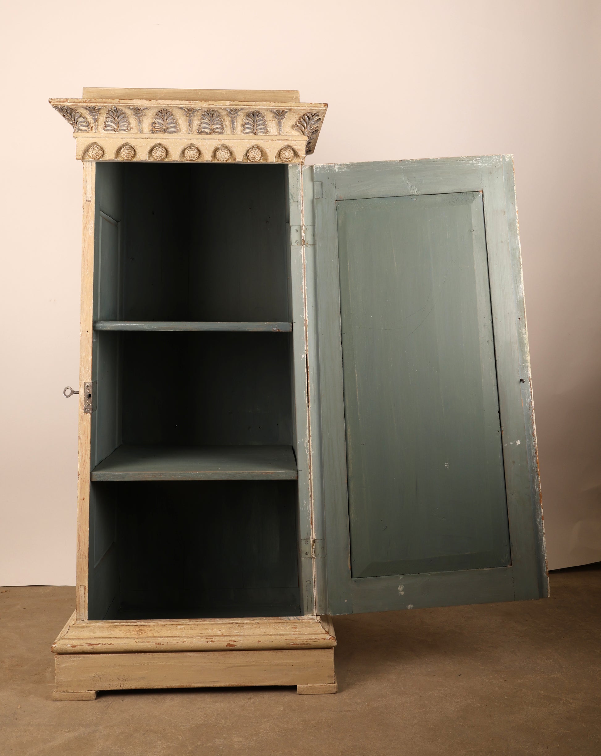 An opened 19th Century Gustavian Column Cabinet with blue shelves.