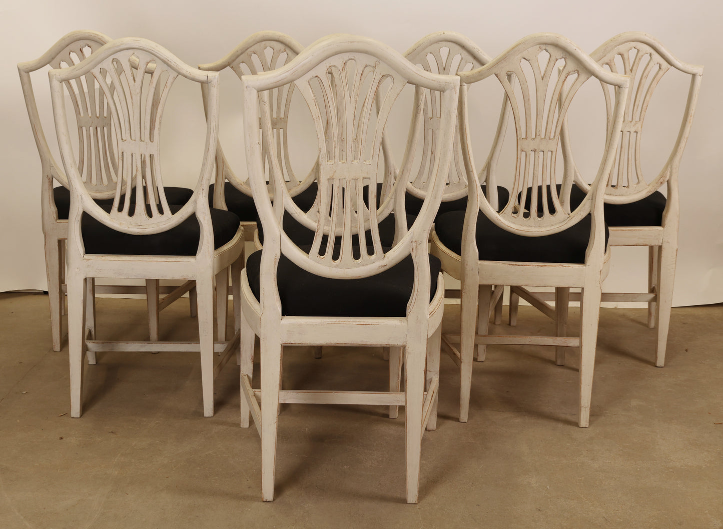 Shields on the backs of eight Gustavian chairs.