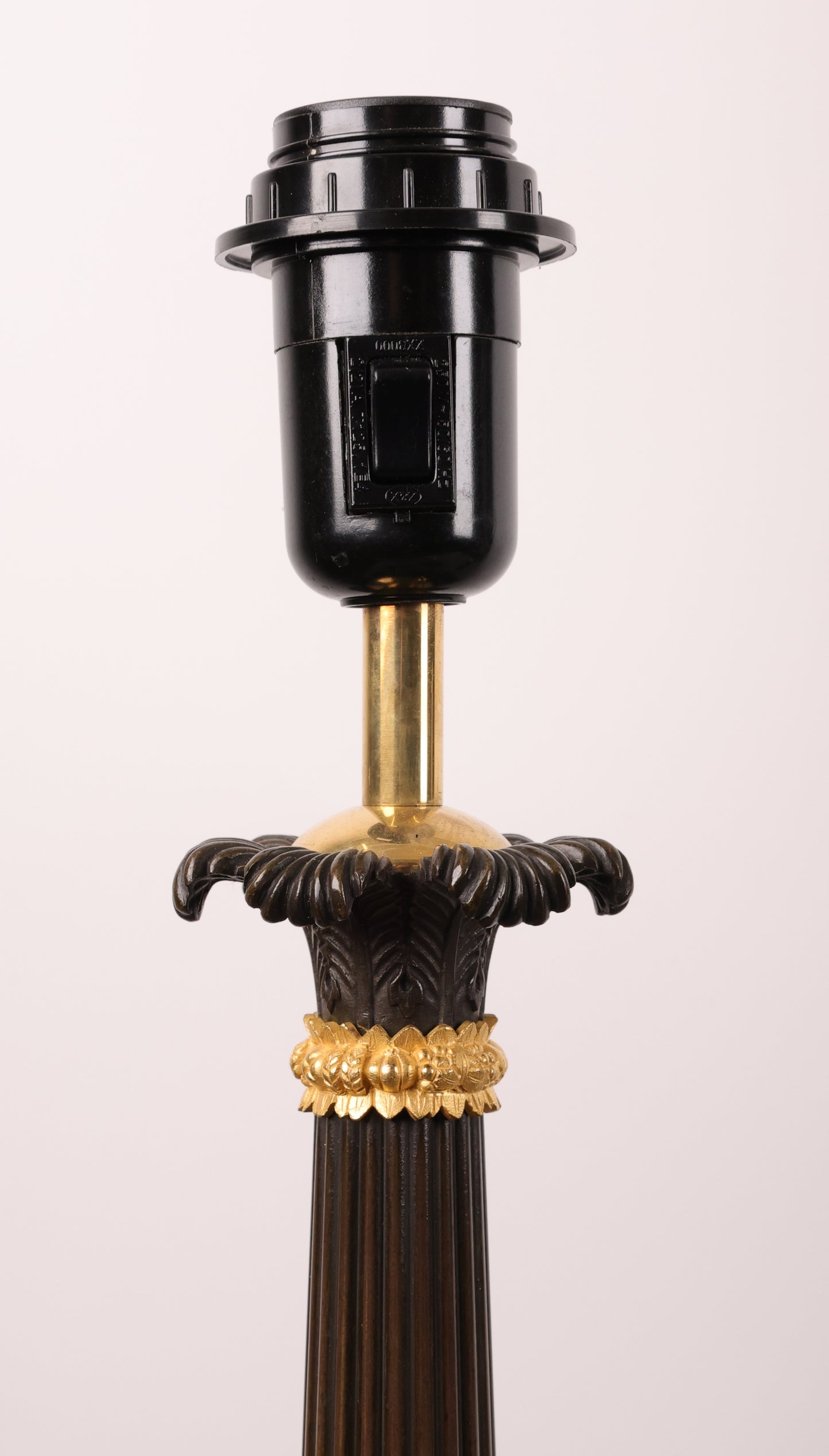 A close up of an antique lamp base from charles X period in dark patinated and fire-gilded bronze.