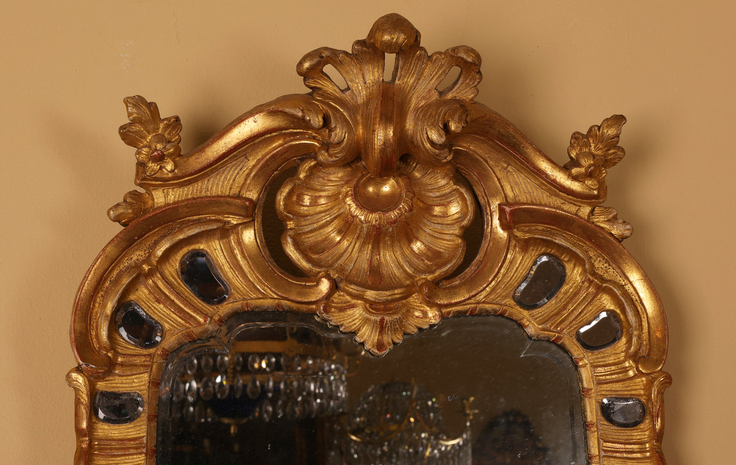 Close up of a gilded antique mirror from the Rococo period.