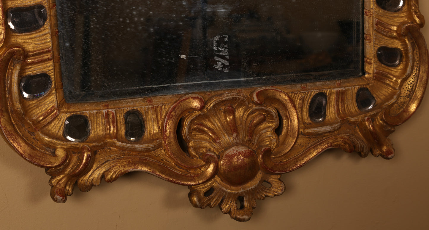 Close up of the frame and the bottom part of an 18th century rococo mirror.