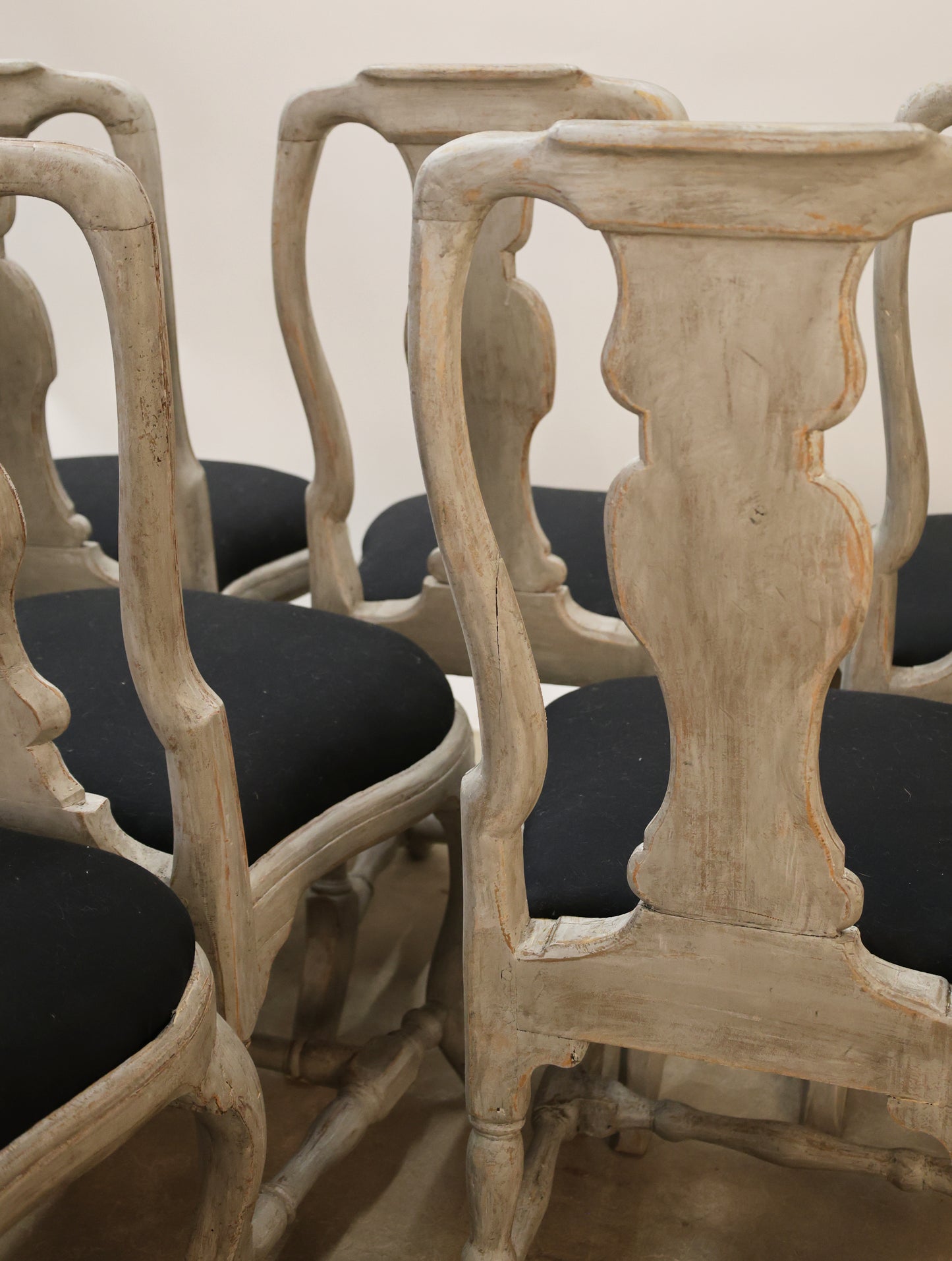 Close up of the backs of a set of eight Rococo chairs
