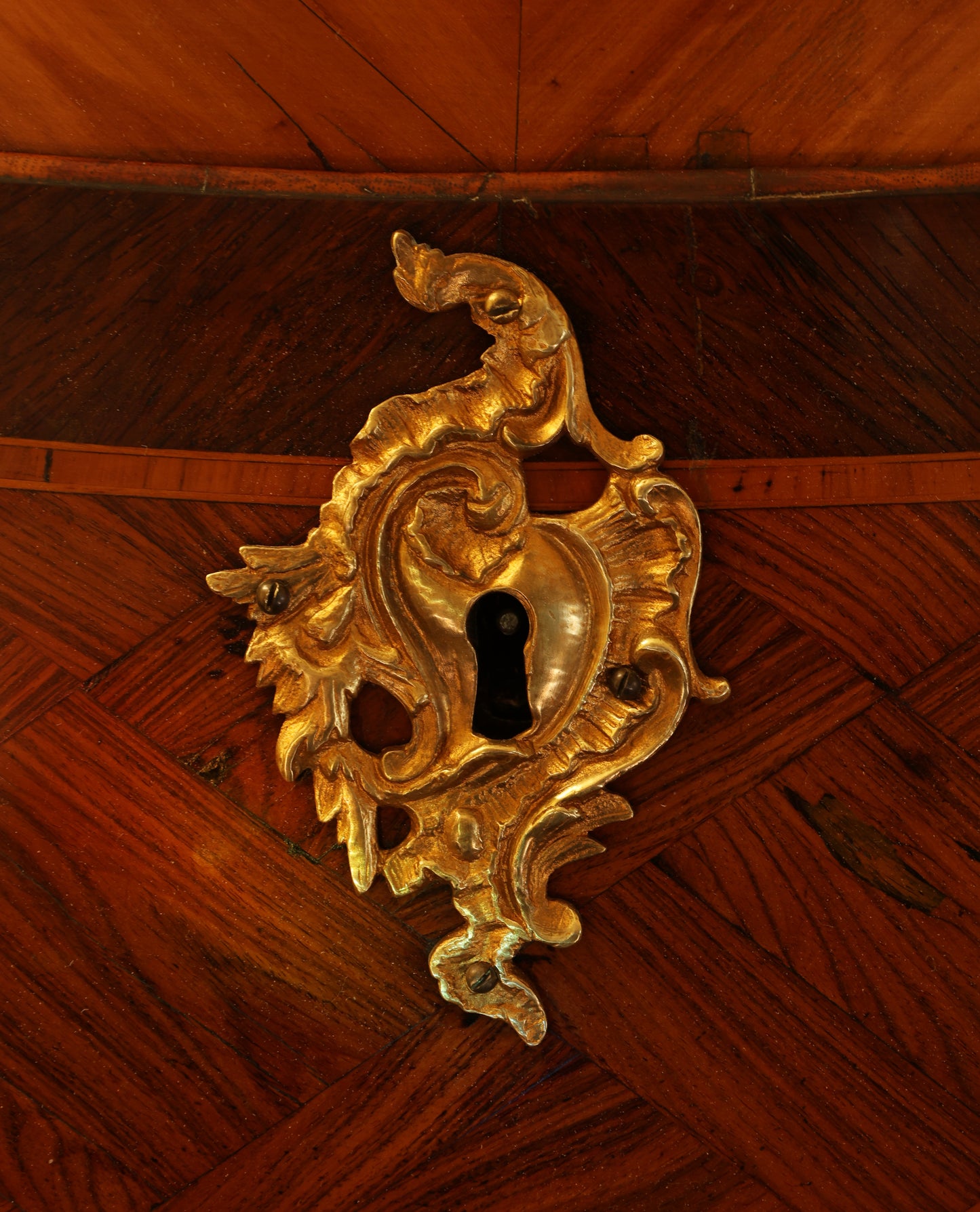 A gilded lock on a Rococo secretary.
