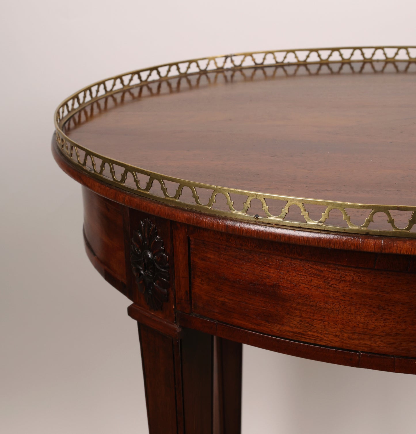 A high-quality antique furniture, in the form of a table. It is mahogany veneered. Close up of the brass balustrade.