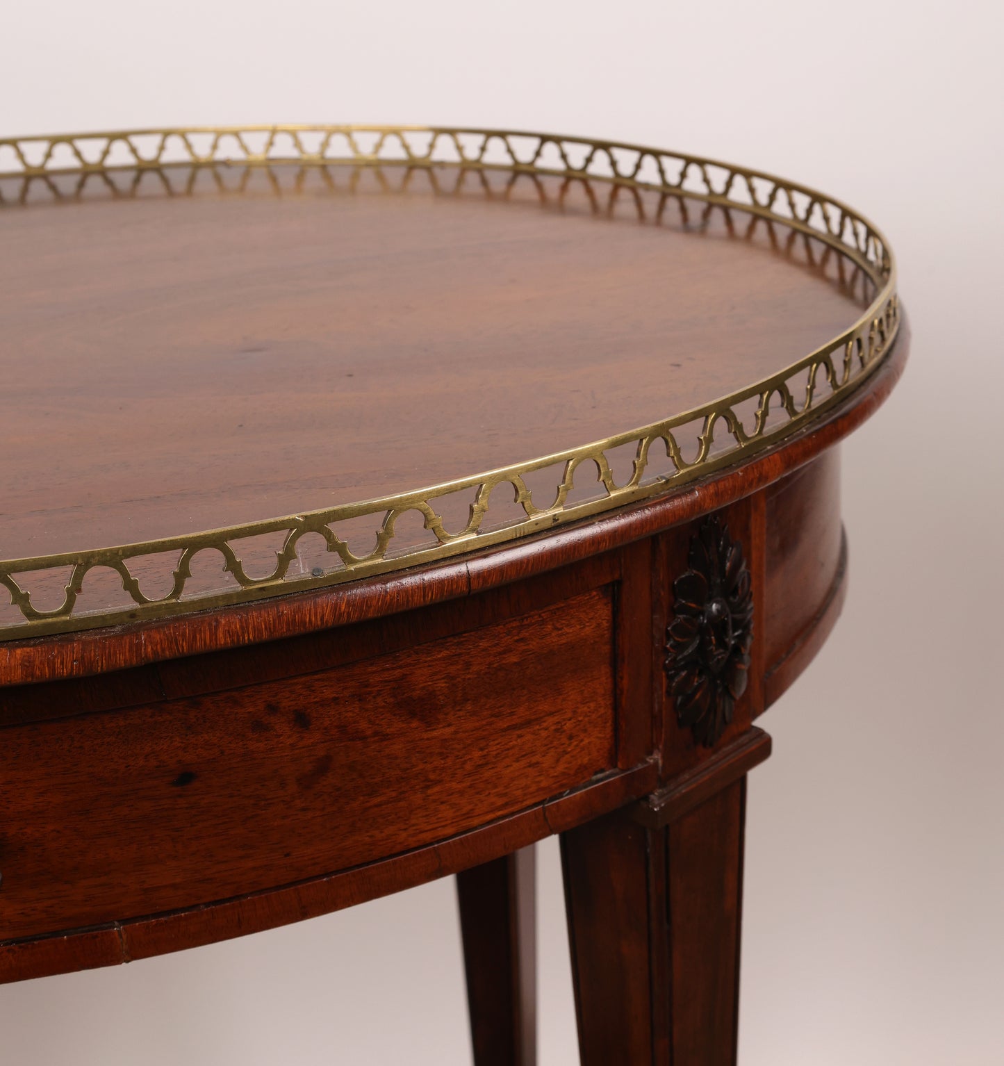 A high-quality antique furniture, in the form of a Gustavian table. It is mahogany veneered. Close up of the brass balustrade.