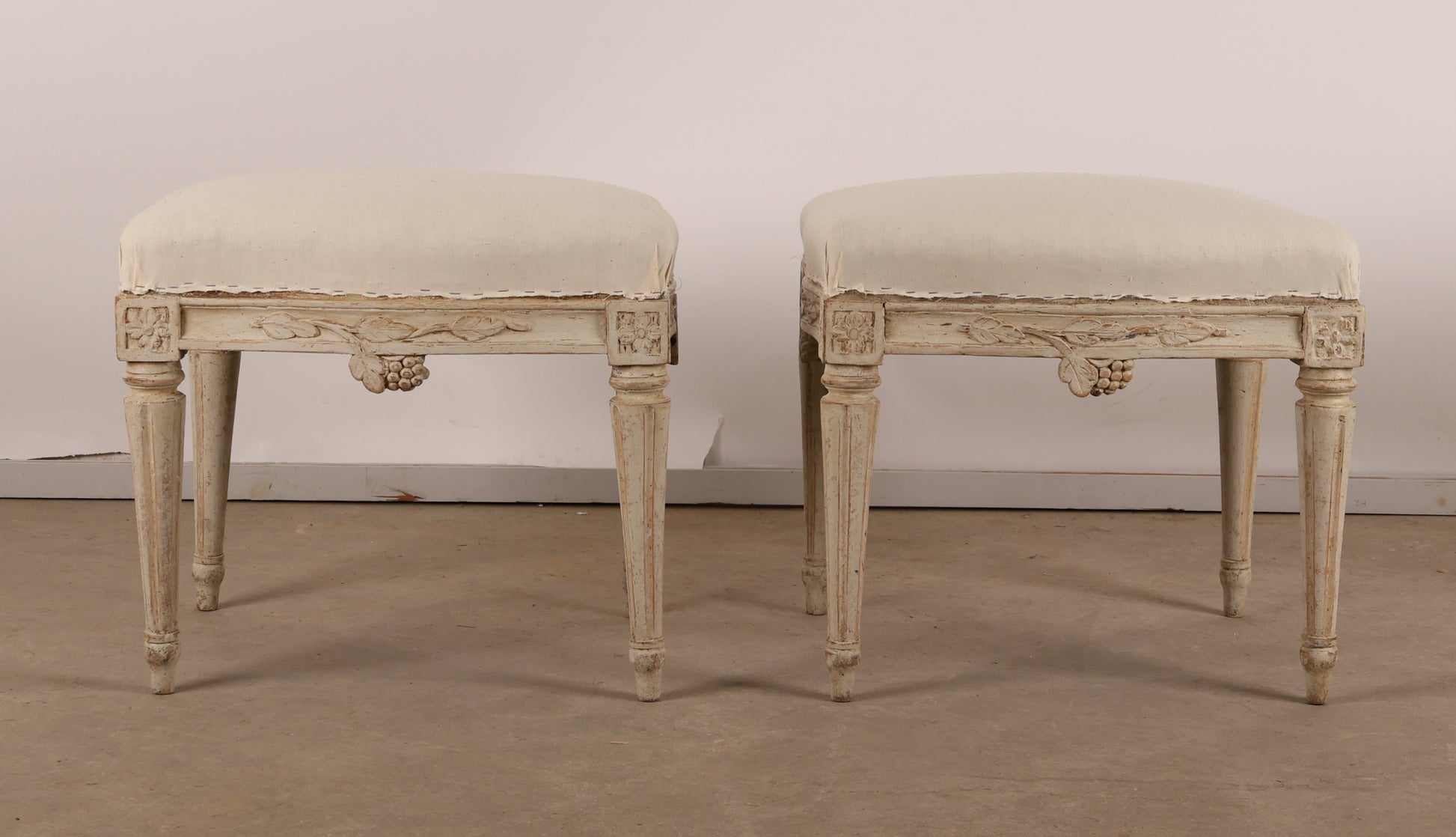 Pair of 18th Century Gustavian Stools signed Johan Erik Höglander with carved decorations of grapes, branches and corner rosettes. The legs are carved with flutings.