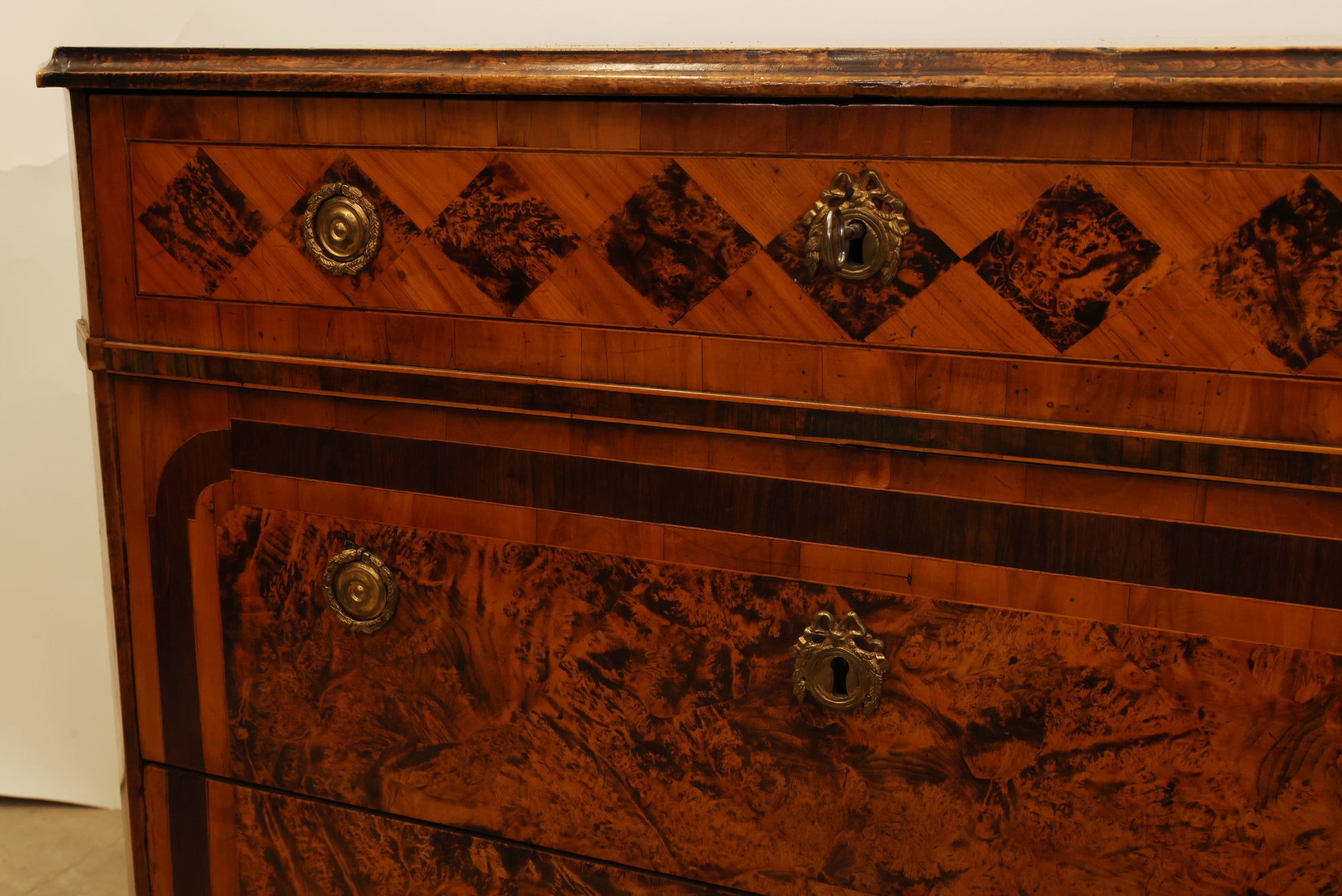 Details on an 18th century chest of drawers in alder root for sale.