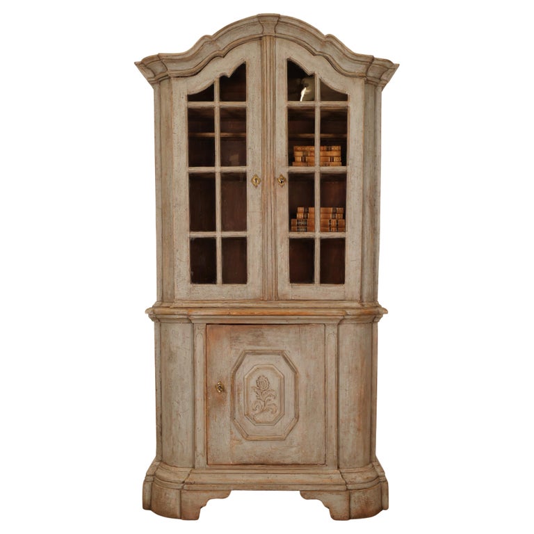 18th Century Rococo Display Cabinet with two glazed doors with hand-blown glass. The door on the lower part of the Rococo cabinet has a carved flower. 