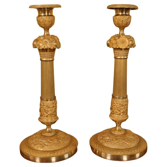 A pair of empire candlesticks with garlands in burnished-gilded bronze for sale.