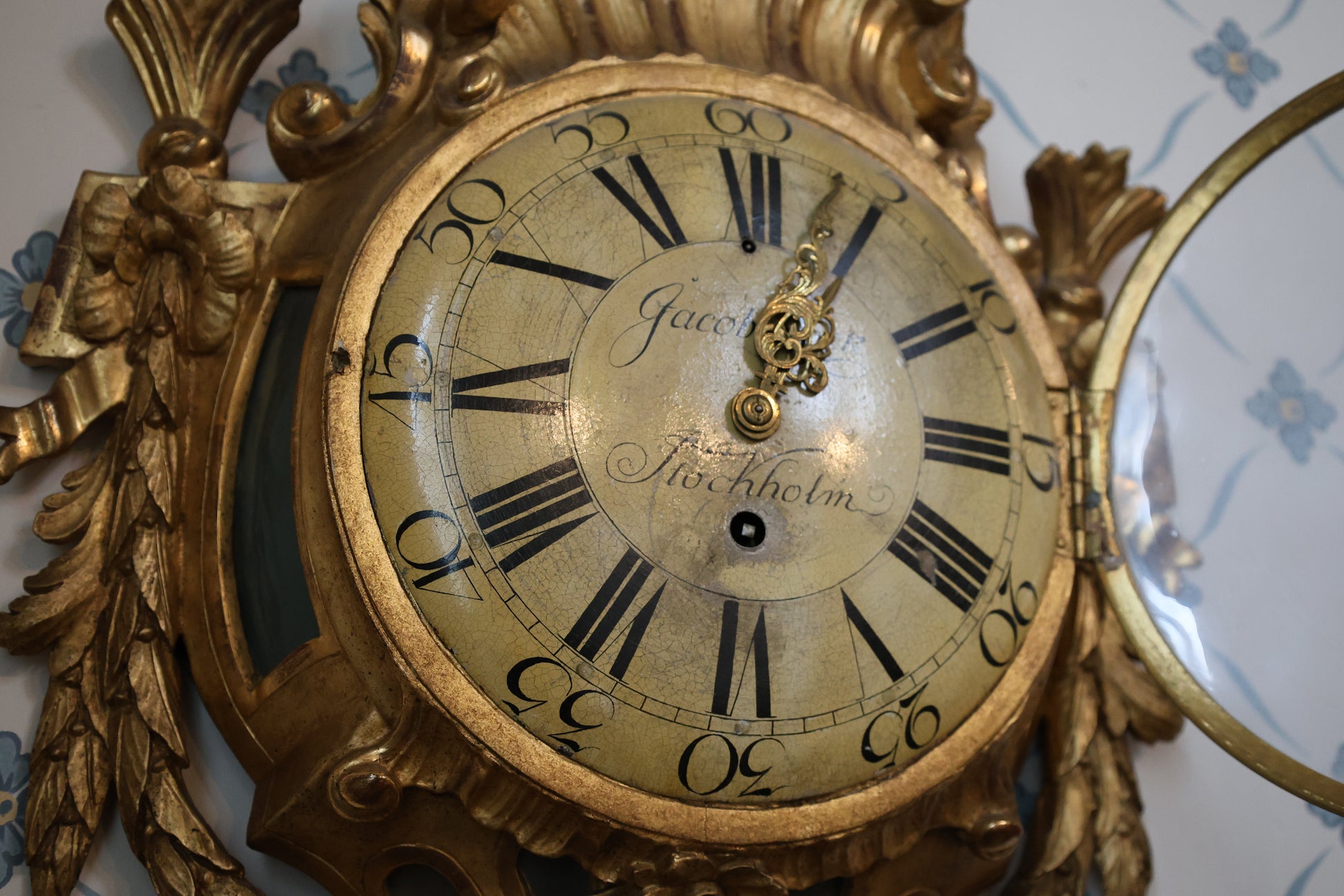 Wall Clock signed Jacob Kock from the transitional period between Rococo and Gustavian styles. The case is entirely carved from wood and gilded. Showing the signature and movement. The enamel dial features Roman numerals.