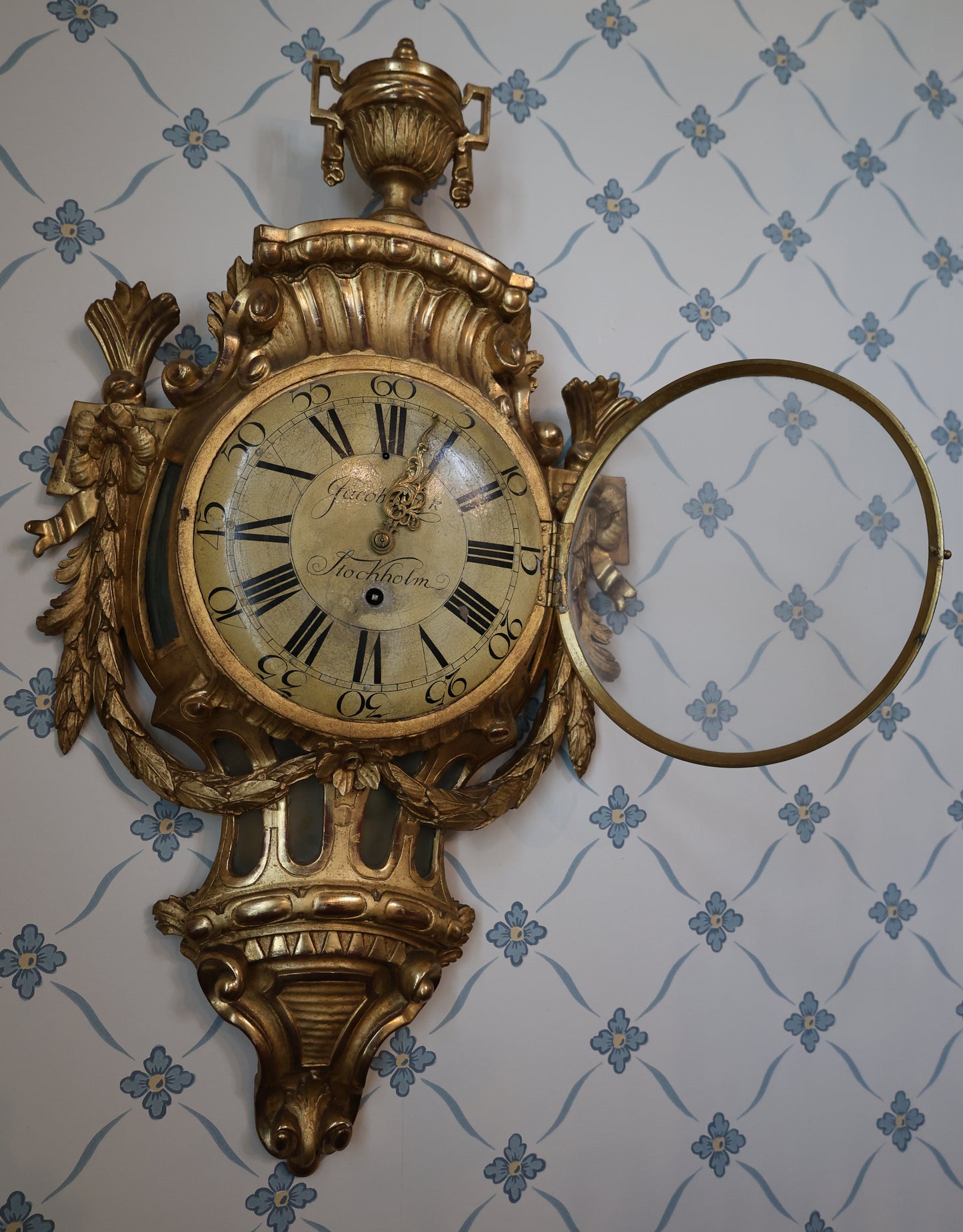 Wall Clock signed Jacob Kock from the transitional period between Rococo and Gustavian styles. The case is entirely carved from wood and gilded.