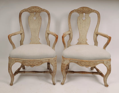 A pair of Rococo armchairs made in Stockholm around 1760/70. Featuring carvings of rocailles with pickering in both the apron and the back. The chairs are equipped with H-stretchers and have removable upholstered seats.