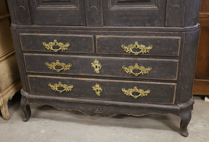 Close up of drawers on a black antique cabinet.