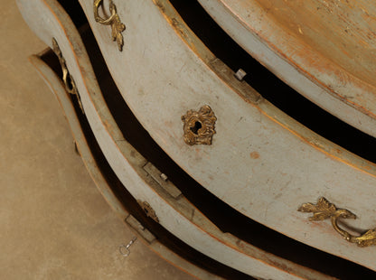 The drawers of a blue Rococo dresser.