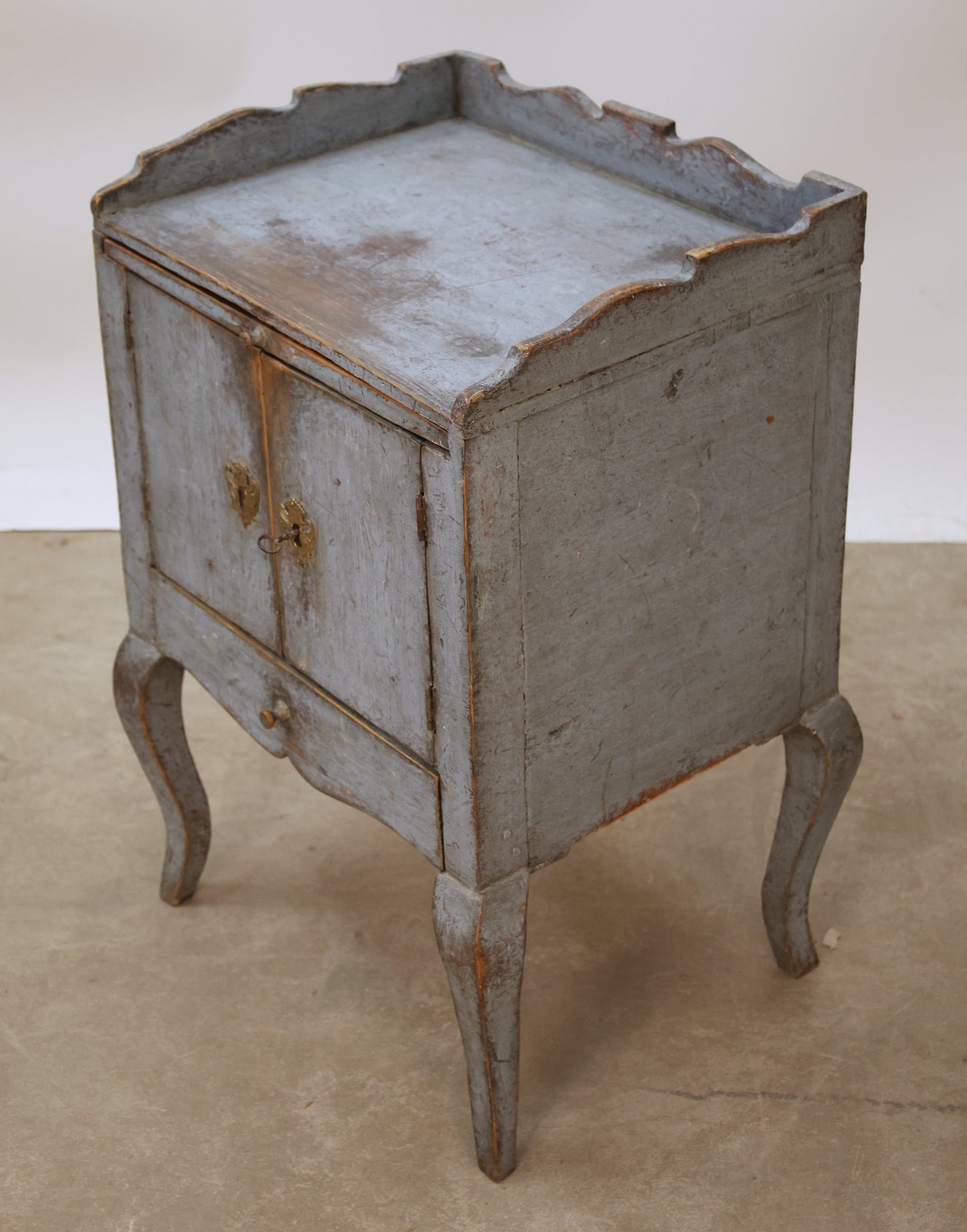 Antique Rococo nightstand viewed from the side.