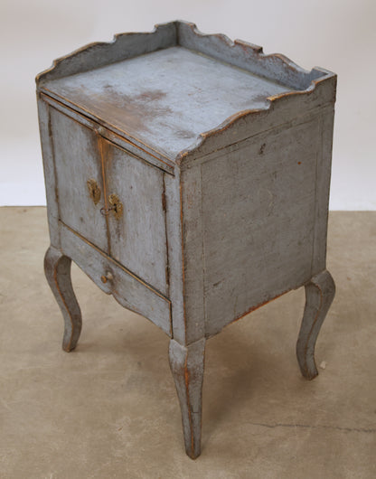 Antique Rococo nightstand viewed from the side.