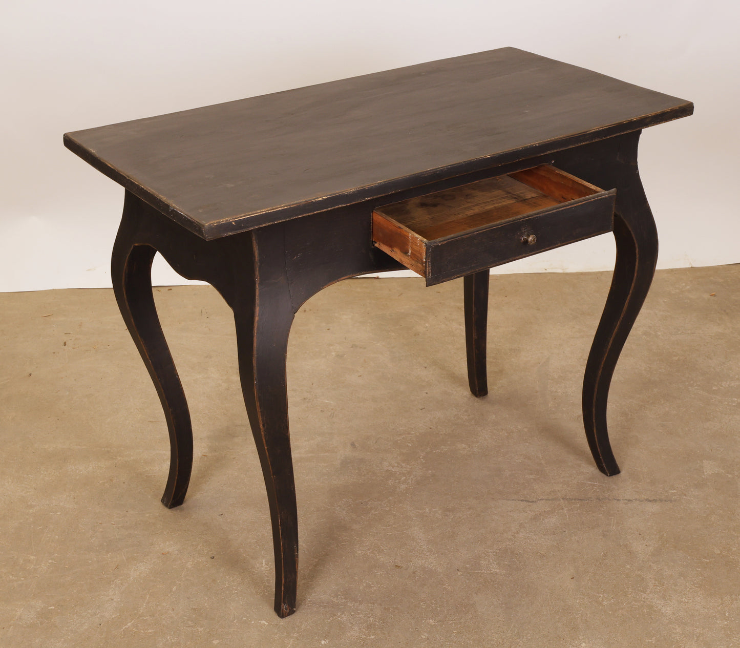 An antique Rococo table with a drawer.