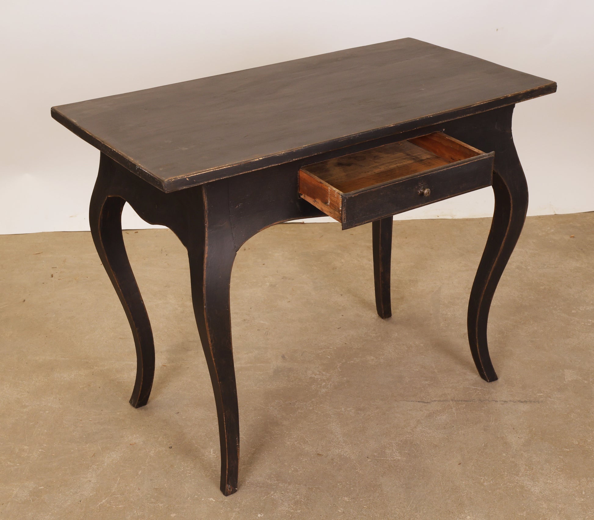 An antique Rococo table with a drawer.