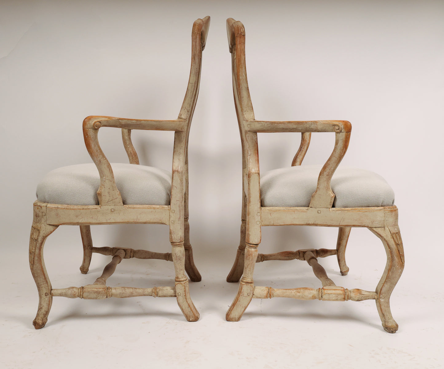 Side view of a pair of antique Rococo chairs from the 18th century with carved rocailles.