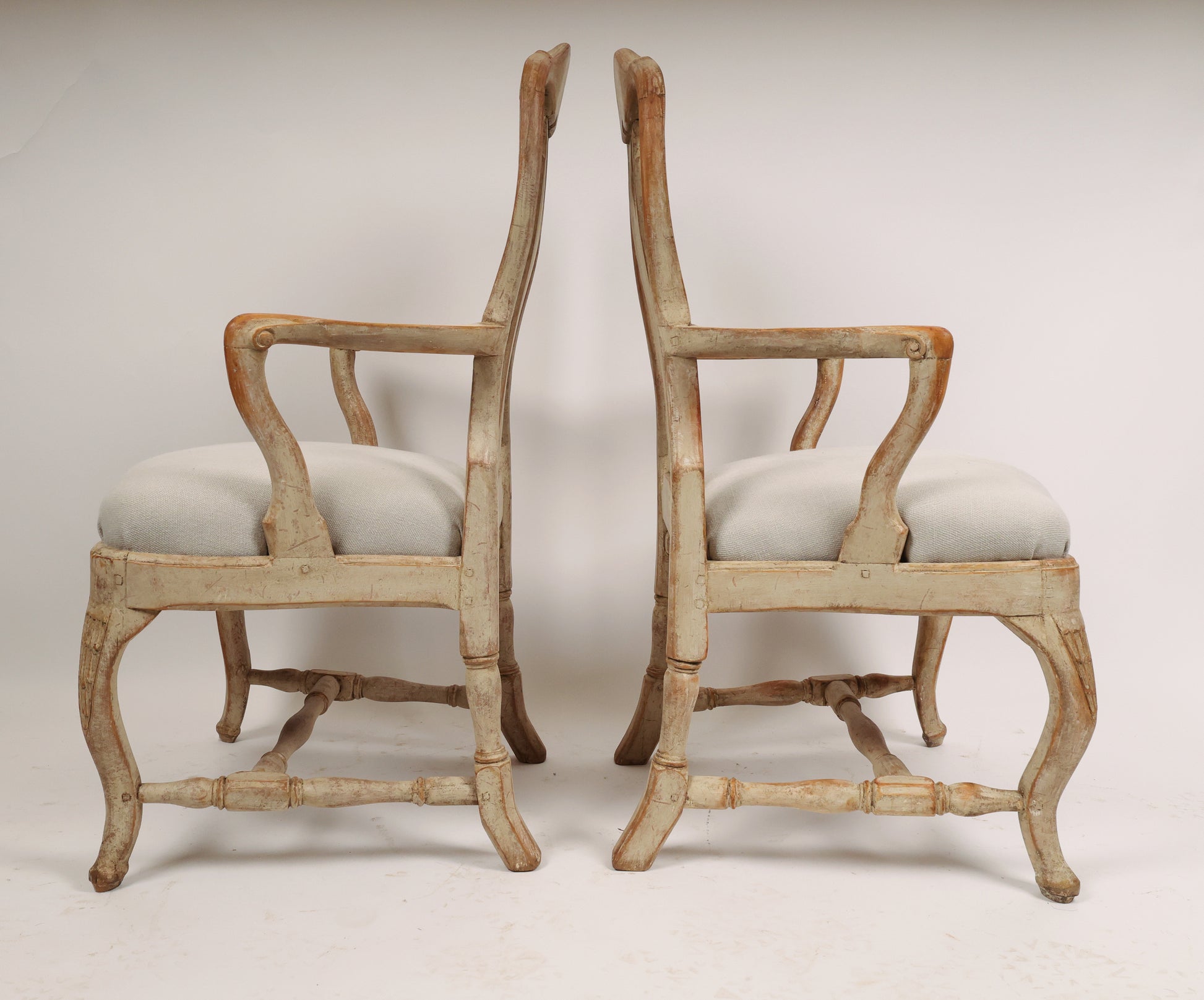 Side view of a pair of antique Rococo chairs from the 18th century with carved rocailles.