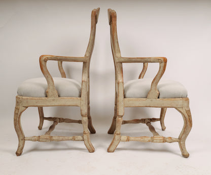 Side view of a pair of antique Rococo chairs from the 18th century with carved rocailles.