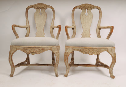 A pair of Rococo armchairs made in Stockholm around 1760/70. Featuring carvings of rocailles with pickering in both the apron and the back. The chairs are equipped with H-stretchers and have removable upholstered seats.