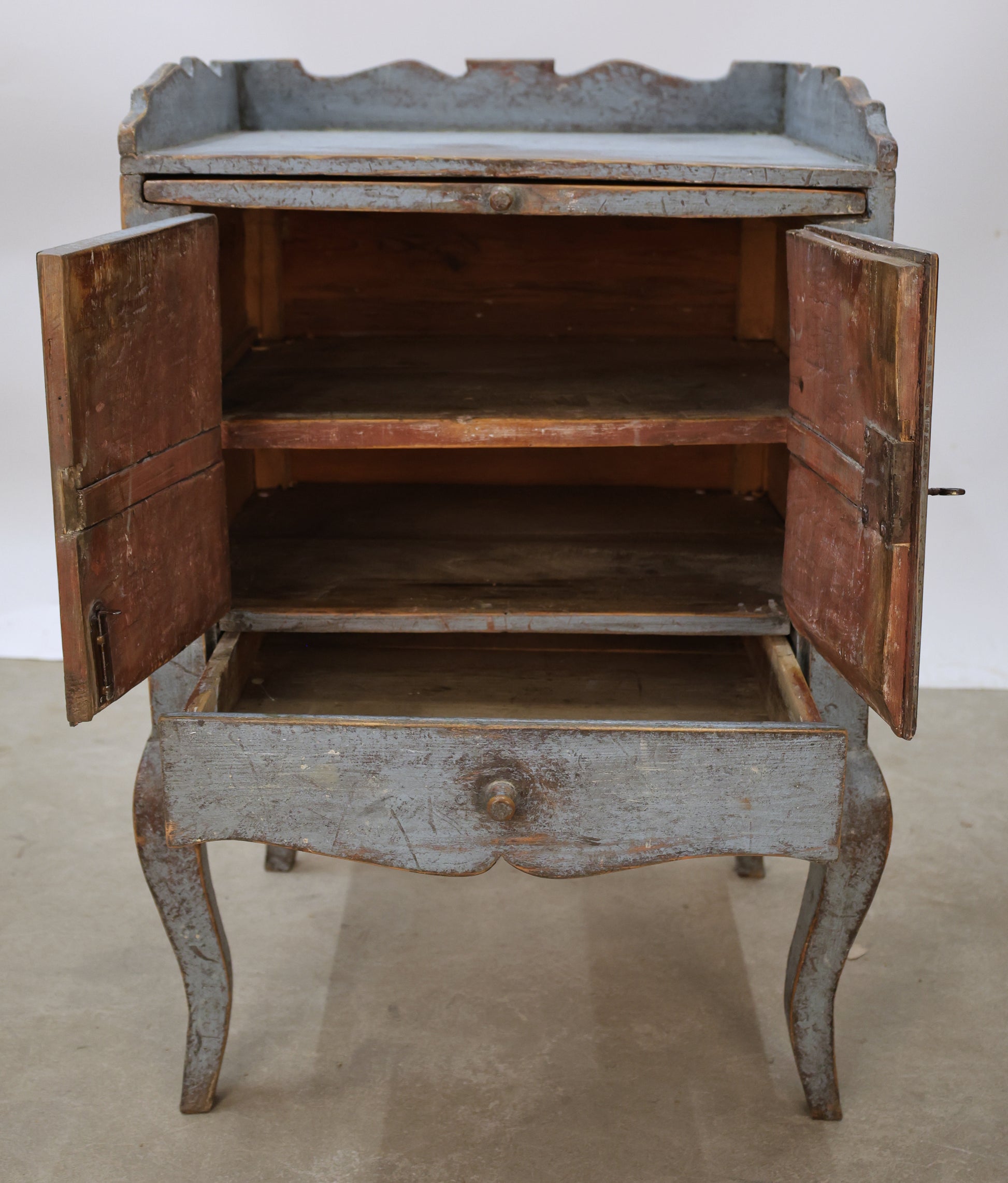 A blue Rococo nightstand with red shelf interior.