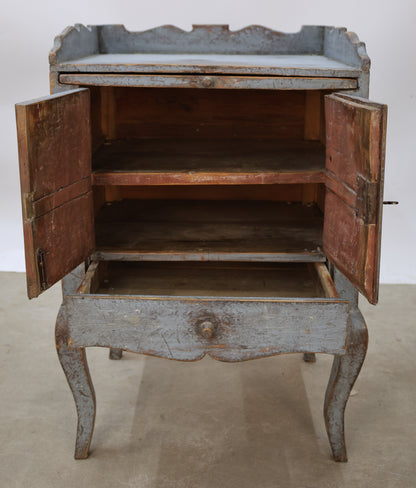 A blue Rococo nightstand with red shelf interior.