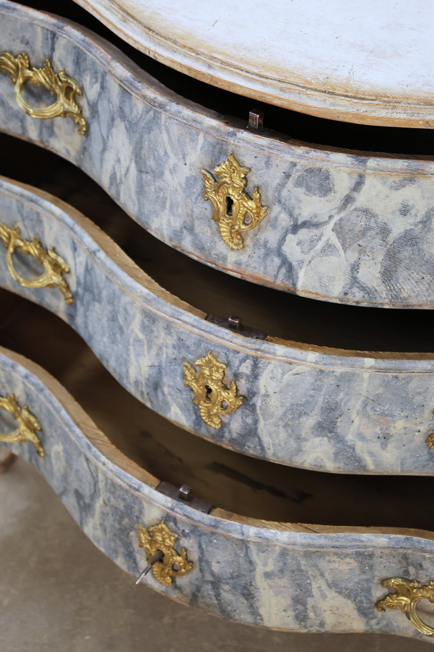 Close up of the drawers on an antique marbled chest.