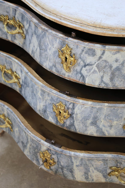 Close up of the drawers on an antique marbled chest.