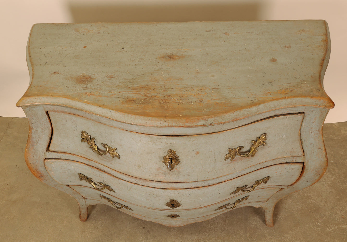 A blue rococo chest of drawers, view from above.