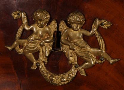 Gilded putto details on an antique Empire secretary.