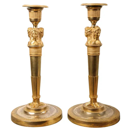 A pair of French fire-gilded Empire candleholders from around 1800-1810. The candleholders are in the Egyptianizing style that was popular at the time, referencing Napoleon's campaigns in Egypt. The candle sleeves are original.