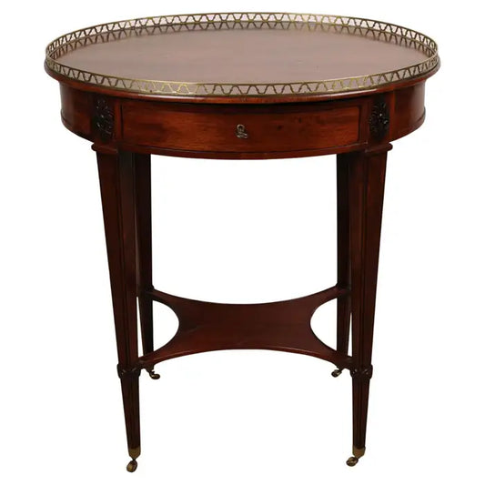 18th Century Late Gustavian Table in veneered and partially solid mahogany with carved wooden decorations of corner florets. The core material is pine and alder. The top is fitted with a brass balustrade. The table features brass castors. White background.