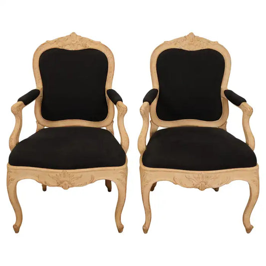 A pair of high-quality Rococo armchairs in the palace style. Made in Stockholm, Sweden in the 1760s. The chairs are adorned with rich carvings on the apron and backrest. With white background.