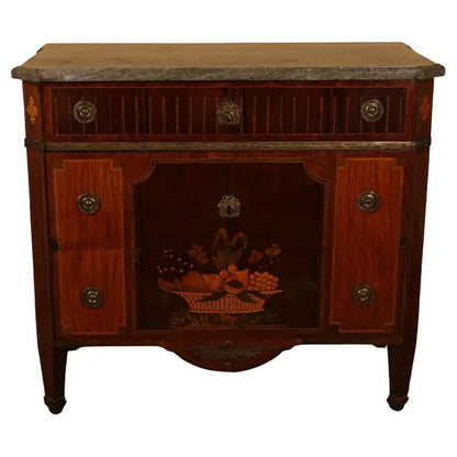 A distinguished high-Gustavian commode, crafted in Stockholm by Gustaf Foltjern (master 1771-1804). The top features an original slab of Kolsmo marble, while the body is veneered in various woods on a frame of pine and alder. The front is adorned with exquisite intarsia work, including a fruit basket design, and the inlay is meticulously engraved with wax. The upper drawer features illusory inlaid cannelures. The body is straight with angled corners, beautifully decorated with fleurons. White background.